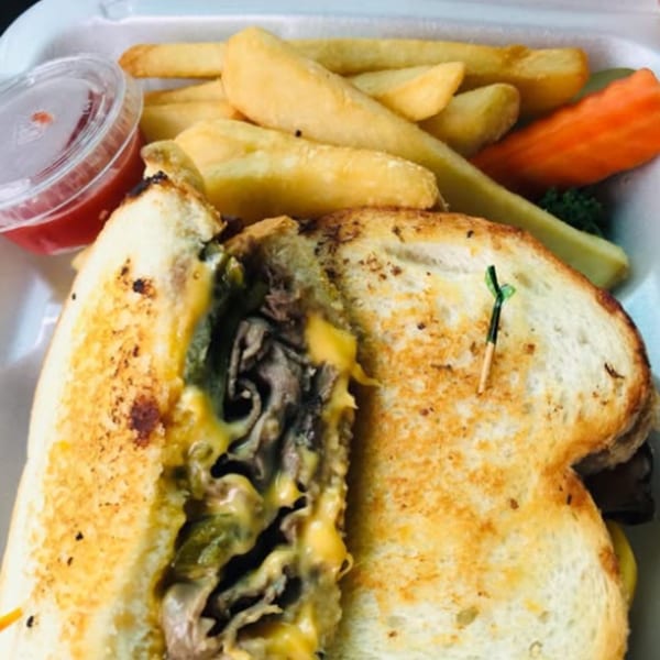 A Mother Hubbard's grilled cheese sandwich with steak and melted cheese, served with fries and ketchup.